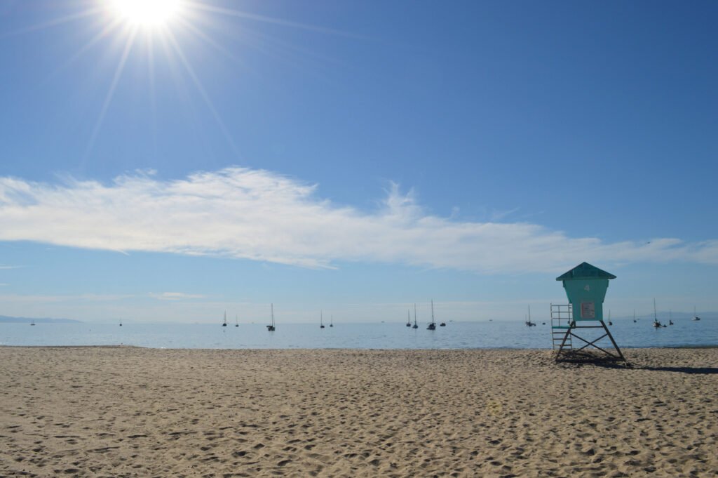Captured in the morning at the end of September, East Beach in Santa Barbara, adjacent to Sterns Wharf, offers a serene coastal scene with golden sands, azure waters, and a tranquil ambiance.