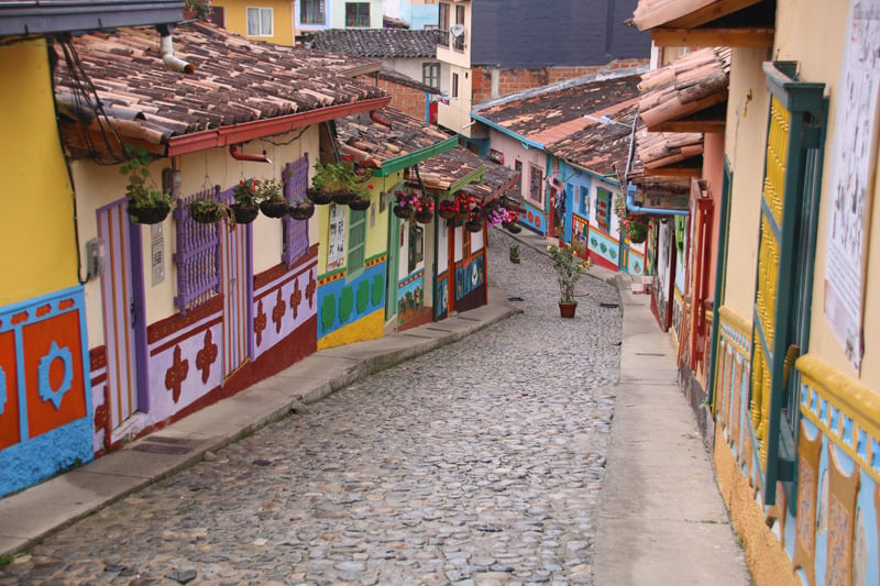 a cobblestone street lined with colorful houses in Guatape, Medellin, Colombia.