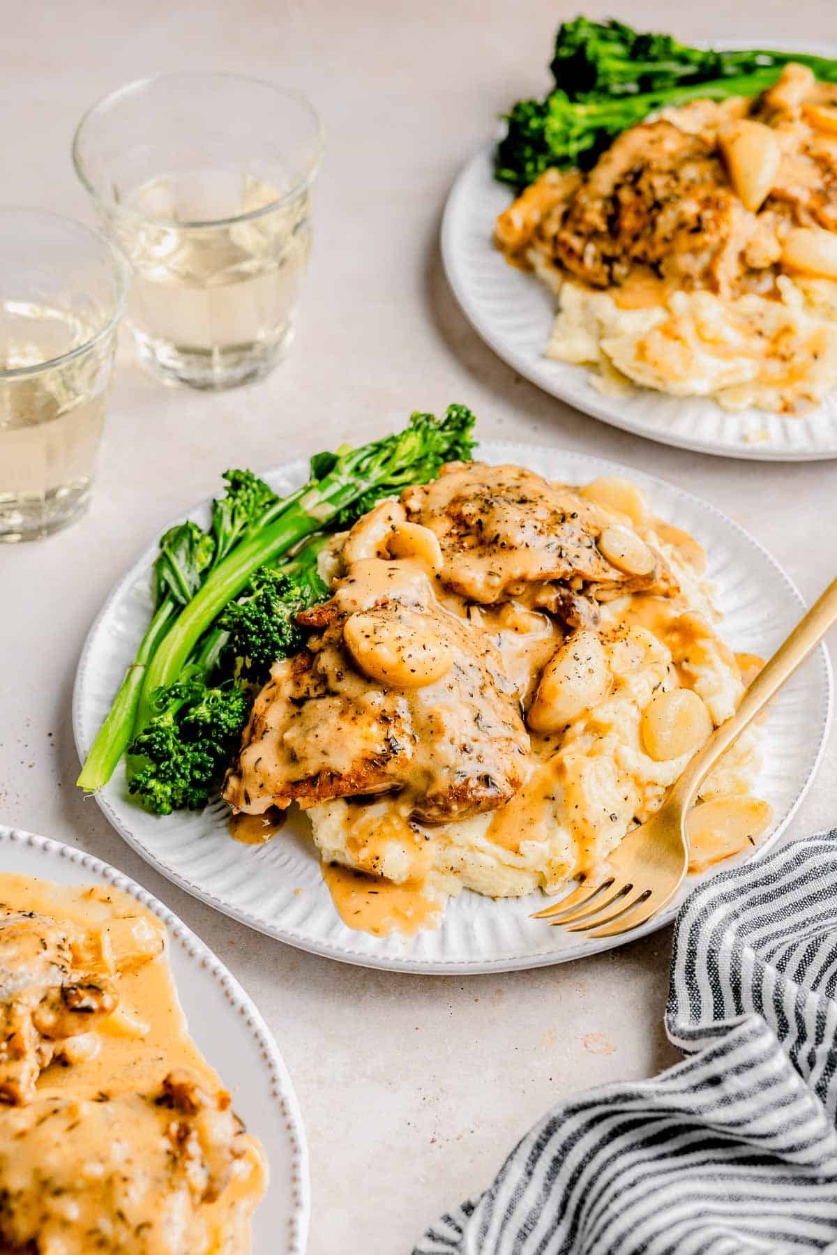 40 clove garlic chicken served on a plates with broccolini.