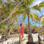 woman gazing up at a palm tree on Playa Holbox